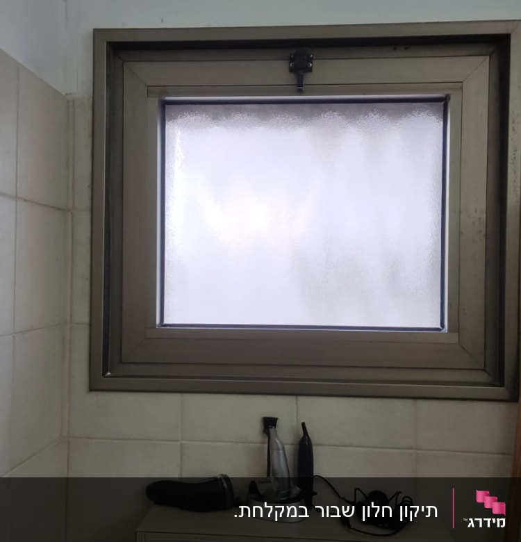 חלון זכוכית חלבית עם מסגרת מתכת אפורה